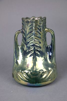 a silver vase that is sitting on a table