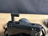 a camera strap attached to a camera on a wooden table