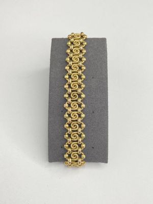 a close up of a bracelet with gold beads on it