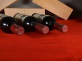 several bottles of wine are lined up on a red table cloth