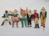 five figurines of different sizes and colors on a white surface