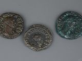 trois pièces romaines, dont l'une représente la tête d'un homme et l'autre celle d'un