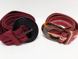 pair of red and black belt with a tortoise buckle