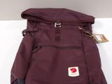 purple and black backpack on a white surface with a tag