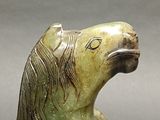 statue of a horse with a long mane on a gray surface