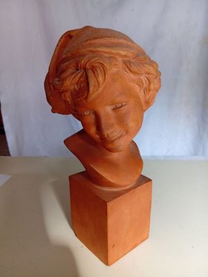 une sculpture en argile représentant la tête d'une femme, posée sur une table
