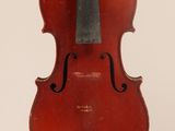 un vieux violon posé sur une table près d'un mur blanc