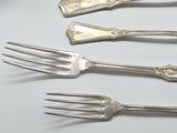 four forks and a spoon sitting on a table