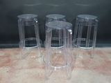 trois tabourets en plastique transparent posés sur un sol recouvert de moquette
