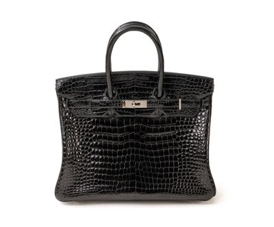 un sac à main en cuir de crocodile noir sur fond blanc