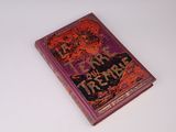 un vieux livre posé sur une table à côté d'une table blanche