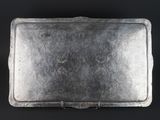 an old metal tray with a handle on a black surface