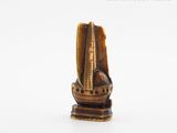 a small statue of a boat on a white surface