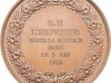 an old bronze medal with a wreath of leaves on it