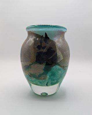 un vase en verre orné d'un cheval, posé sur une table