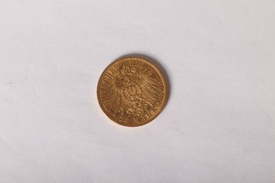 gros plan d'une pièce d'or sur une surface blanche