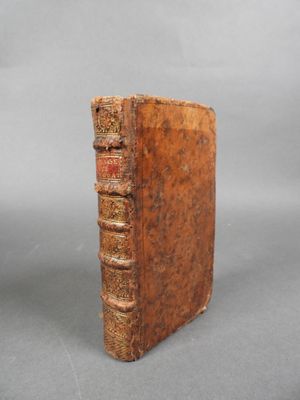un vieux livre posé sur une table à côté d'un fond gris