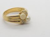 an image of a gold ring with pearls and diamonds on a white surface