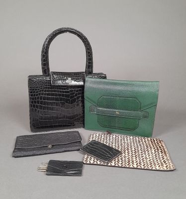 two purses, a wallet, and a card case are sitting on a table