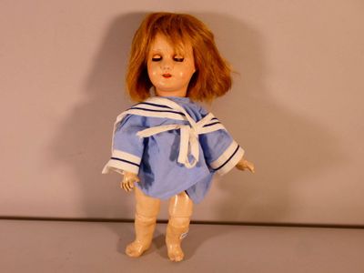 une poupée qui porte une robe bleue et un nœud blanc