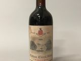 an old bottle of wine sitting on top of a white table