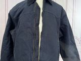 jacket on a mannequin stand in front of a white wall