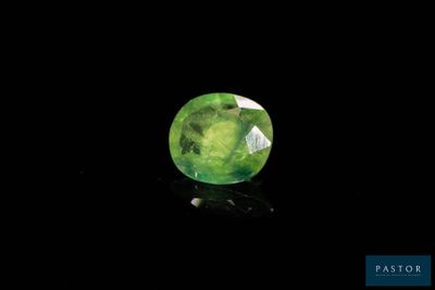 a close up of a green gemstone on a black background