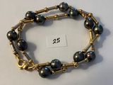 une photo d'un bracelet orné de perles noires