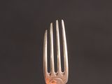 a close up of a silver fork on a black background