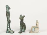 three bronze figurines of a man and a cat and a dog