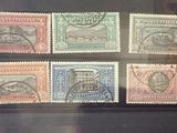 quatre timbres de couleurs différentes exposés dans une vitrine en verre