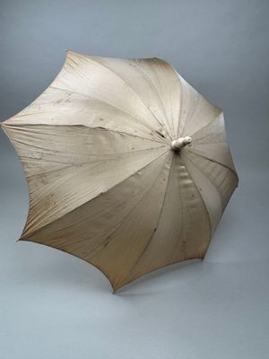 un parapluie blanc ouvert sur fond gris