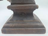 a statue of a cat sitting on top of a wooden base