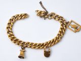 un gros plan d'un bracelet à chaîne en or orné de breloques