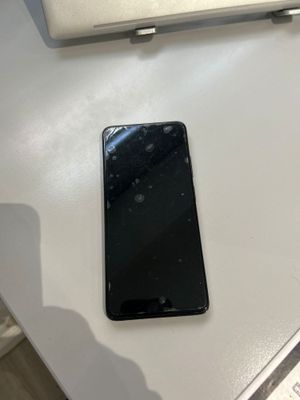 un téléphone portable noir posé sur une table à côté d'un ordinateur portable
