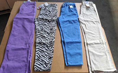 Plusieurs pantalons de différentes couleurs sont alignés sur une boîte en carton