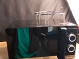 un micro-ondes posé sur une table devant une chaise