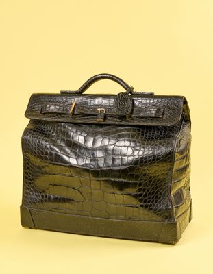 porte-documents en cuir d'alligator noir sur fond jaune, avec un espace réservé au texte