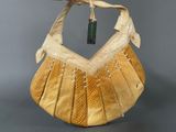 a yellow purse with a white ribbon on it