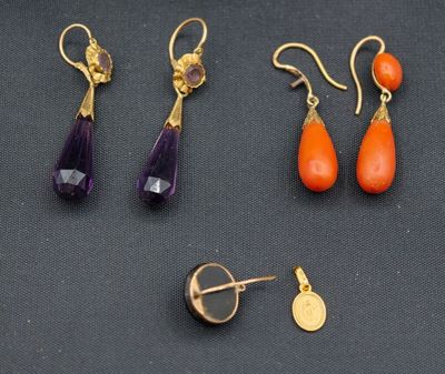 trois paires de boucles d'oreilles et une broche posées sur un fond noir