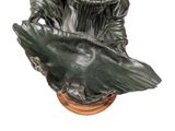 statue of a woman holding a bird on a wooden base