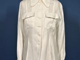 a white shirt on a mannequin stand against a blue wall