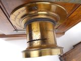a close up of a brass object on a wooden table