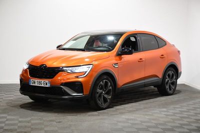 une voiture orange vif garée dans une pièce au sol à carreaux
