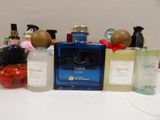 many different bottles of perfume sitting on a table