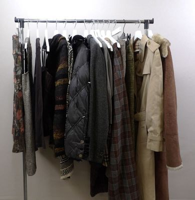 a lot of coats hanging on a rack in a room