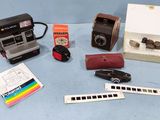 un appareil photo Polaroid, un appareil photo Polaroid à pellicule, une règle et d'autres objets posés sur une surface bleue