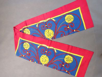 une écharpe rouge et bleue ornée d'une fleur jaune