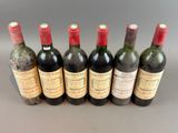 six bottles of wine are lined up in a row on a table