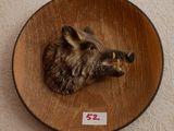 une image représentant une tête de sanglier fixée sur une plaque en bois
